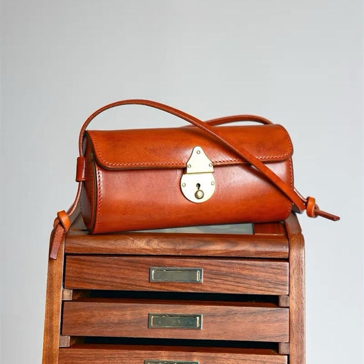 Vegetable tanned leather barrel bag with vintage cylinder silhouette and crossbody strap