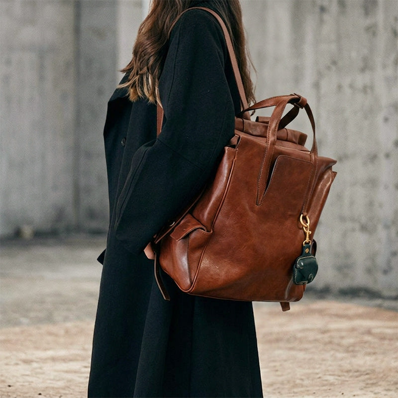 Brown vegetable-tanned leather convertible backpack tote with top handles and adjustable straps