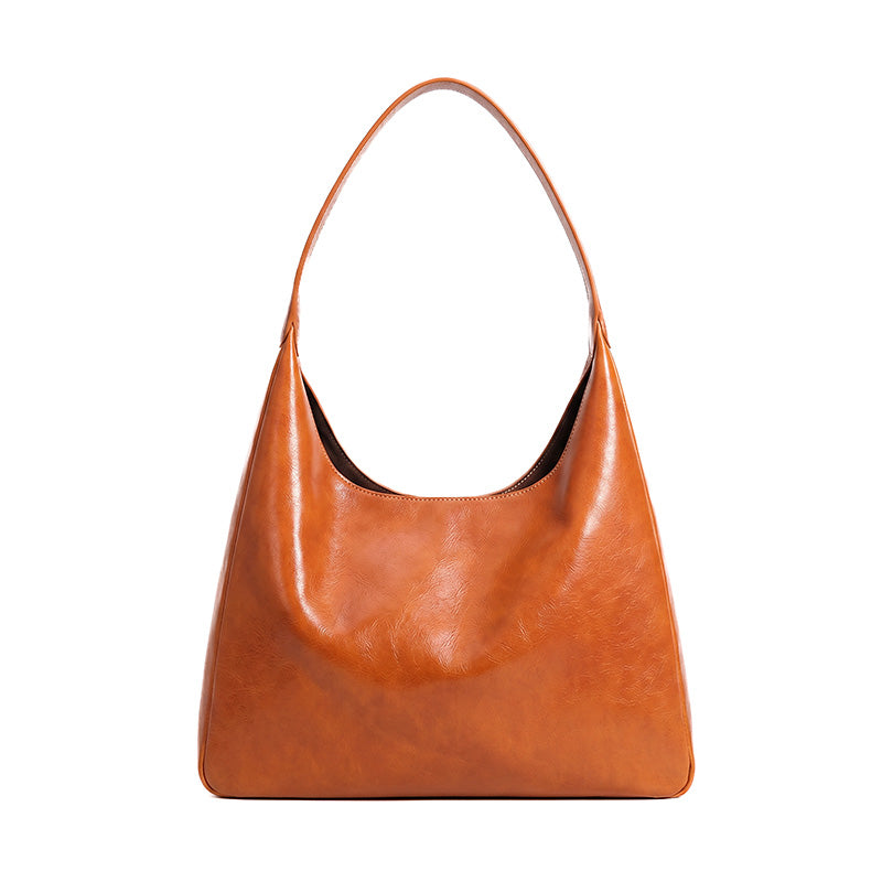 Structured vegetable tanned leather hobo bag in orange with a back zip pocket and shoulder carry