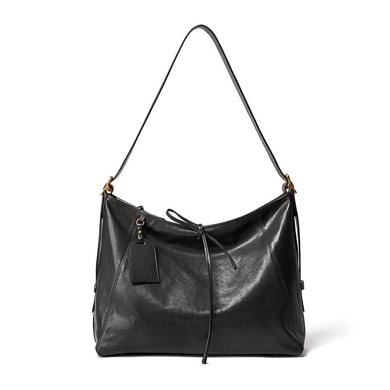 Black vegetable tanned leather tote bag with top handles and adjustable shoulder strap