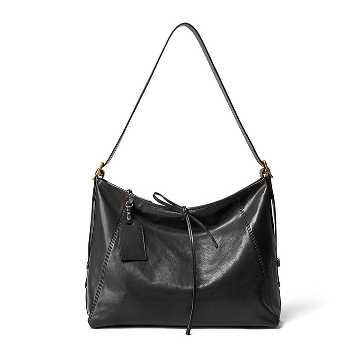 Black vegetable tanned leather tote bag with top handles and adjustable shoulder strap