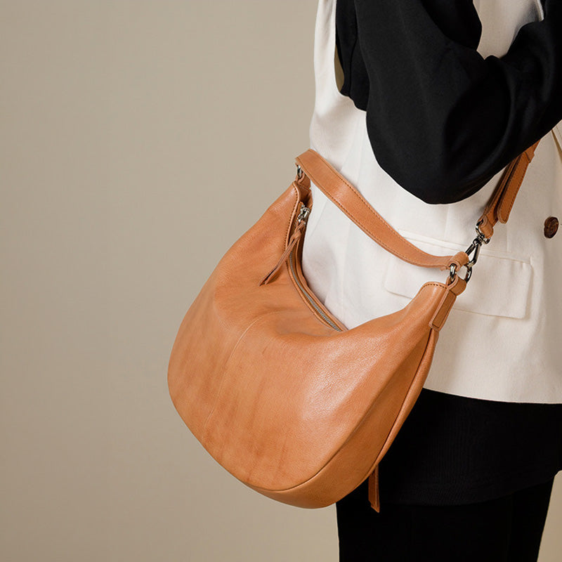 Yellow water-dyed calfskin leather hobo bag with natural grain texture and adjustable strap.