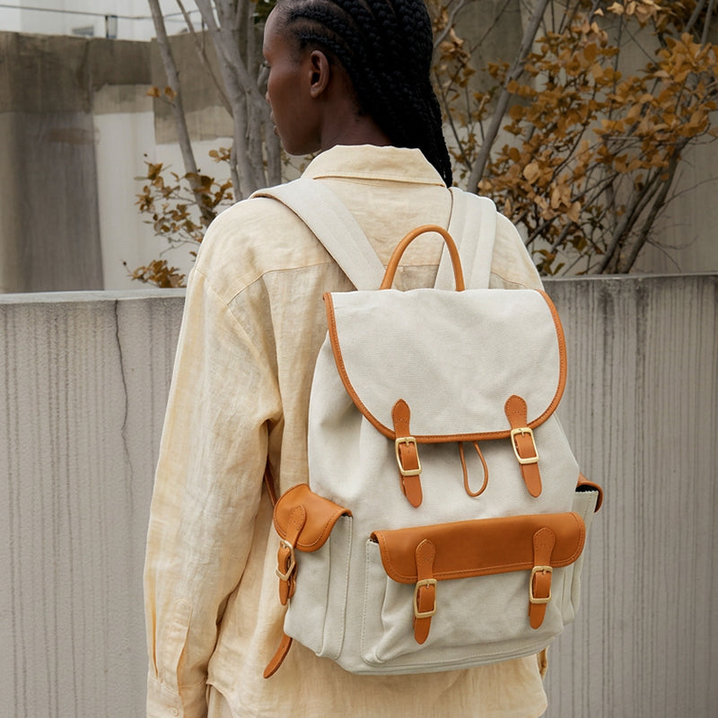 Woman wearing a waxed canvas leather backpack with vintage buckle straps outdoors