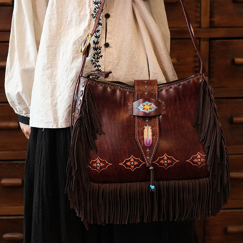Model carrying a brown leather shoulder bag with Western detailing and long fringe.