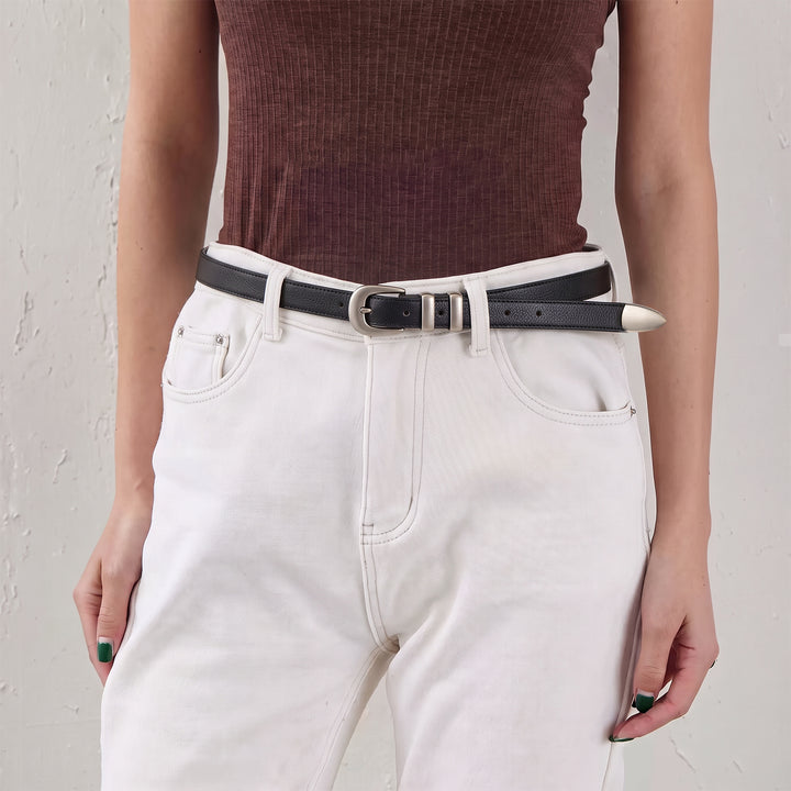 Woman wearing a skinny black leather belt with a silver-tone buckle and white jeans.