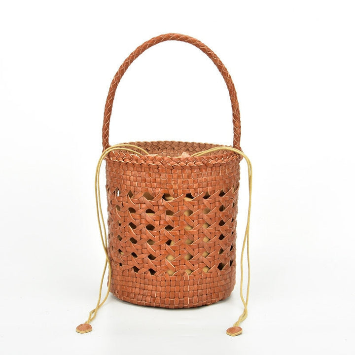 Handmade woven leather bucket bag in brown with hollow-out design and braided handle