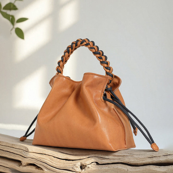 Yellow cowhide leather bucket bag with woven handle and drawstring closure
