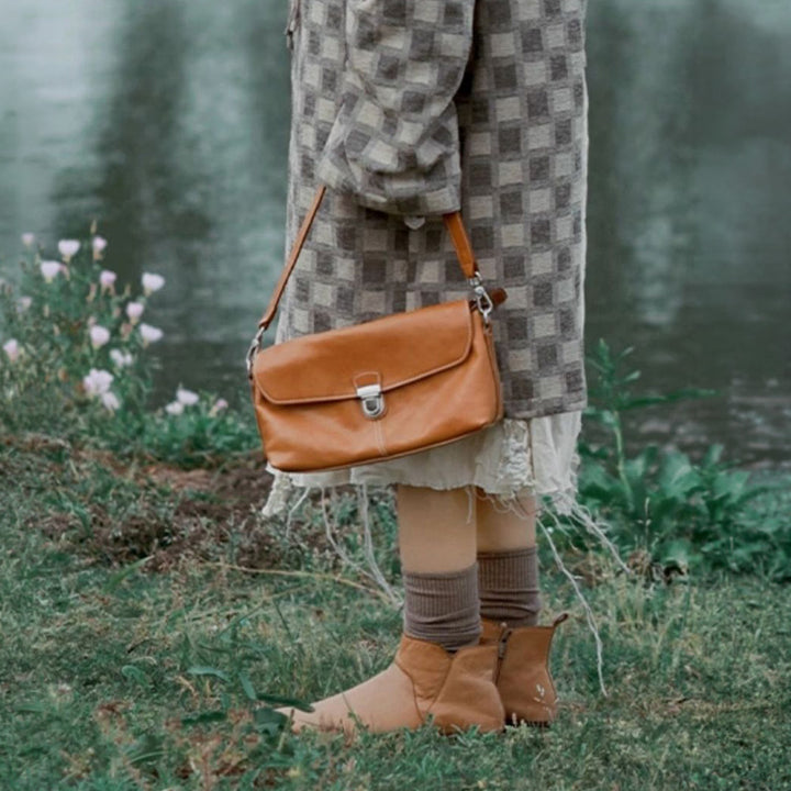 Yellow vegetable tanned leather crossbody bag with gold snap closure and detachable strap